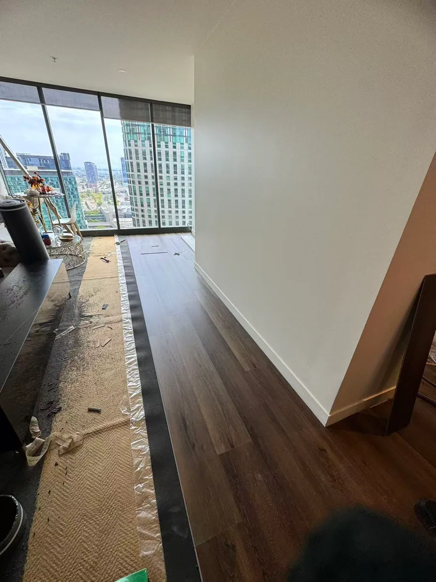 Owner-supplied photo of a long flooring run through an apartment hallway