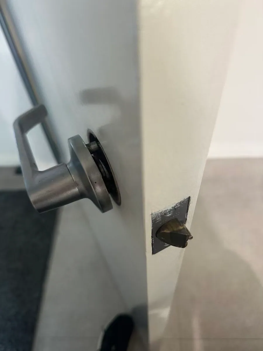 Owner-supplied close photo of a front-door latch repair area